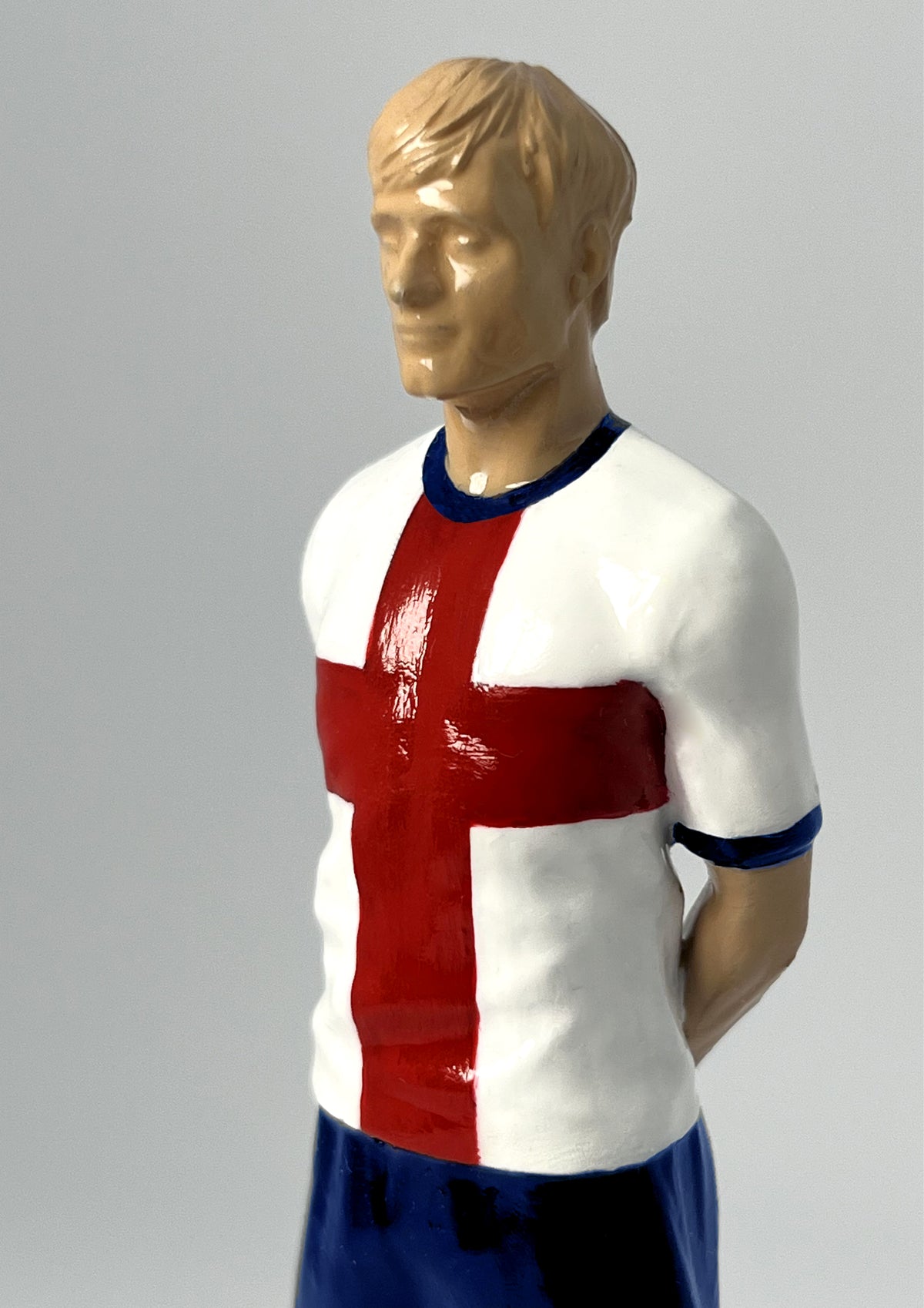 Figurine de collection Match Day FC équipe d'Angleterre (n°7), maillot blanc à la croix de Saint-Georges, vue de profil.